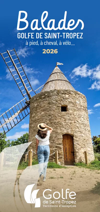 Brochure des balades avec la photo d'un moulin à vent en vieille pierres. Une femme est devant et le regarde avec sa main sur son chapeau. Le ciel est bleu avec quelques nuages. 